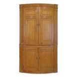 Early 19th Century stripped pine bowfront two section corner cupboard fitted four doors, 110cm wide