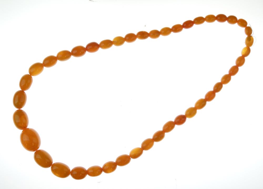 Row of graduated amber beads, the forty-three barrel shaped beads, 1.3cm to 2.8cm long, overall