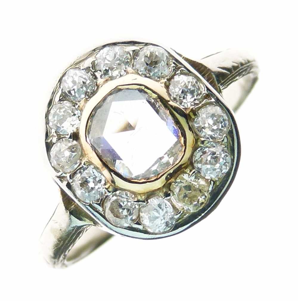 Diamond cluster ring, set to the centre with an oval rose cut diamond enclosed by twelve old cut