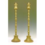 Pair of tall brass table lamps, each standing on a flared circular foot with an oak base, 80cm high