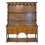 19th Century oak high dresser, the plate rack with moulded cornice, shaped apron below and fitted