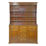 19th Century oak dresser, the later plate rack having a moulded cornice, pierced frieze below and