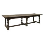 Antique oak refectory dining table having a carved arcaded frieze and standing on six tapered turned