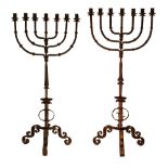 Near pair of wrought and cast iron floor standing seven branch candelabra, each standing on a tripod