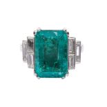 A platinum and Columbian emerald ring Weighing approx. 5,50 carats and flanked by baguettes-cut