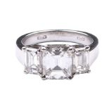 An important 18K white gold and diamond trilogy ring With three emerald-cut diamonds, the central