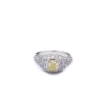 An 18K white gold and natural fancy yellow diamond 'trombino' ring The diamond in the center is a