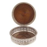 A set of two wooden and silvered metal coasters Pierced borders and engraved wood bases 20th century