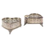A set of two silvered metal heart-shaped baskets Completely pierced silvered metal bodies,