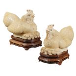 A pair of ivory jewellery boxes modelled as two crouching hens on gilt and engraved wooden bases