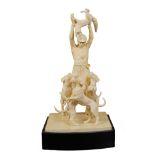 An English ivory group finely decorated ivory, modelled as a huntsman surrounded by his dogs and