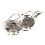 A pair of glass and silvered metal carafes Shaped as a duck 20th century h. 18 cm.