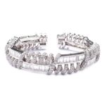 An 18K white gold and diamond bracelet Decorated with spiral-shaped and linear elements,