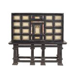 An Italian ebonized wood cabinet a central drawer framed by turned columns with mounted above a Ruin