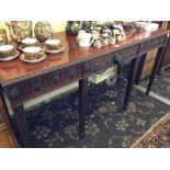 A mahogany side table with centre drawer with ram's head handle, resting on carved sabre supports.