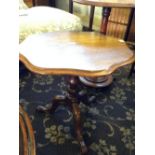 A mahogany occasional table resting on cabriole supports.