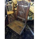 A 19th century carved oak hall chair with floral decorated back, resting on squared cross stretcher