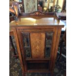 An early 20th century mahogany music cabinet within inlaid urn decoration to door and shelved