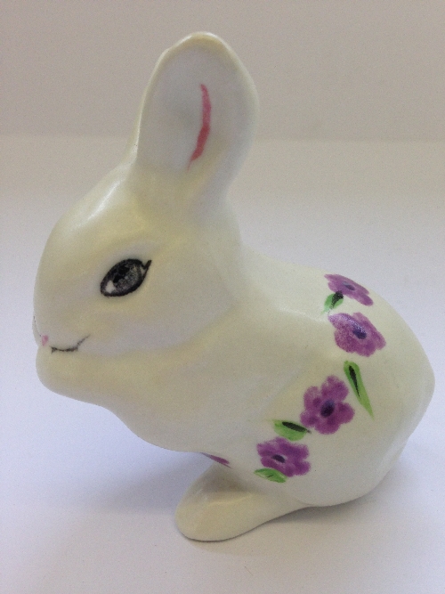 A Poole Pottery model of a Rabbit, decorated with small purple flower heads.