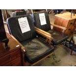 A pair of mid 20th century retro design African hardwood framed armchairs with leather seats.