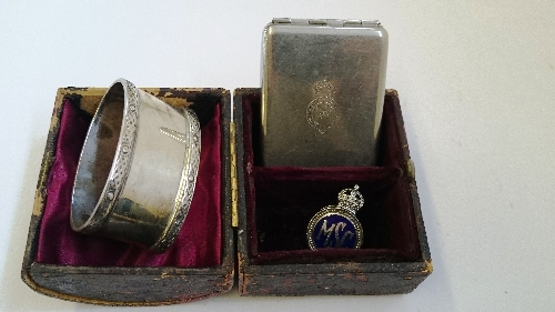 A silver serviette ring together with a metal match case,