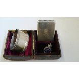 A silver serviette ring together with a metal match case,