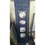 A Chinese hardwood panel inset with four various famille rose plaques decorated with foliage and