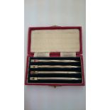 A set of four engine turned silver propelling pencils in original case.