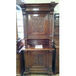 A 19th century heavily carved oak hall cupboard with carved panelled doors,