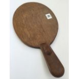 Robert Thompson: A Mouseman oak cheese board with carved mouse to handle (15 inches overall).