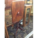 A 19th century mahogany snap-top occasional table, resting on outstretched triple supports.