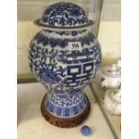 A Chinese blue and white china vase with cover on hardwood stand.