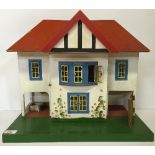 Triang or similar Doll's House, wooden construction with tinplate windows and wooden door.