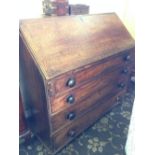 A Georgian oak bureau with fitted interior and four drawers under.