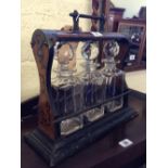 A late 19th century walnut and brass mounted three decanter Tantalus with lock and key.