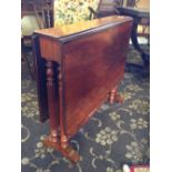 A drop-leaf mahogany Sutherland table, resting on pillar supports.