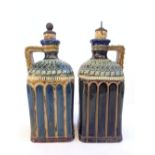 A pair of Doulton Lambeth stoneware spirit flasks decorated in tones of blue and green with incised