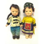 Two 20th Century Oriental composition dolls, with painted faces, black wigs and silk clothing.