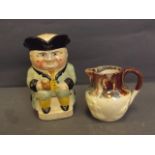 A glazed stoneware Toby jug of a seated man holding a tankard, and a small marble glazed harvest