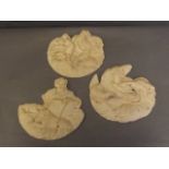 Three pottery wall plaques depicting classical figures sitting in clouds, 7'' wide