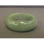 A Chinese apple jade bangle, 2¾'' diameter