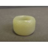 A Chinese light green jade carved archers ring, 1'' diameter