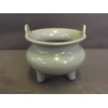 A Chinese celadon ground crackle glazed censer with twin handles and tripod supports, 3½'' diameter