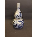 A C19th Chinese double gourd shaped porcelain vase decorated in the blue and white palette depicting