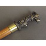 A bronze handled walking stick in the form of a guard dog's head with classical scroll design,