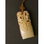 A late C19th/early C20th Chinese carved ivory pendant with dragon and bat decoration,