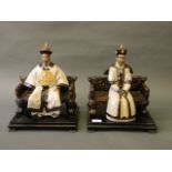 A pair of Chinese crackle glazed pottery figures of a nobleman and his wife, on wood stands,