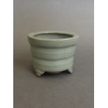 A Chinese celadon glazed pottery incense burner on tripod supports, 2½'' high,