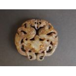 A chinese calcified jade pendant with carved and pierced twin dragon decoration,