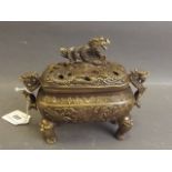 A Chinese bronze censer with twin dragon handles and pierced cover with dragon knop, the body with
